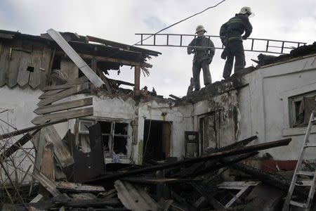 Firefighters work amidst the debris of a house, which according to locals was recently damaged by shelling, in Donetsk, February 3, 2015. REUTERS/Alexander Ermochenko