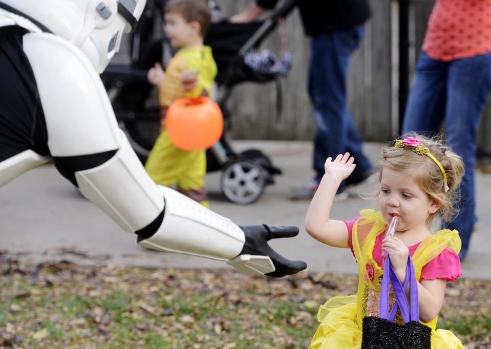 Dressed as Princess Belle, 3-year-old Brielle Reed gives a high-five to a Storm Trooper at ZooBoo in this file photo from 2014 at the Great Plains Zoo.