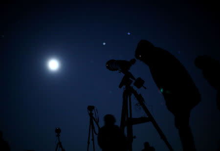 People monitor the moon ahead of a total lunar eclipse in Vienna, Austria, January 21, 2019. REUTERS/Lisi Niesner