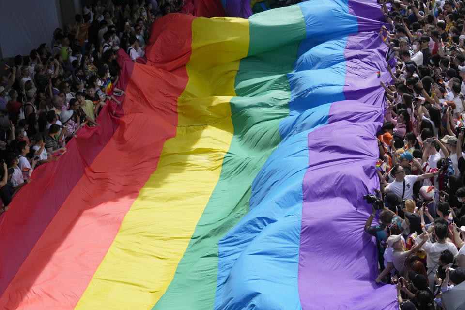 FILE - Participants hold a rainbow flag during a Pride Parade in Bangkok, Thailand, on June 4, 2023. Lawmakers in Thailand's lower house of Parliament overwhelmingly approved a marriage equality bill on Wednesday, March 27, 2024, that would make the country the first in Southeast Asia to legalize equal rights for marriage partners of any gender. (AP Photo/Sakchai Lalit, File)