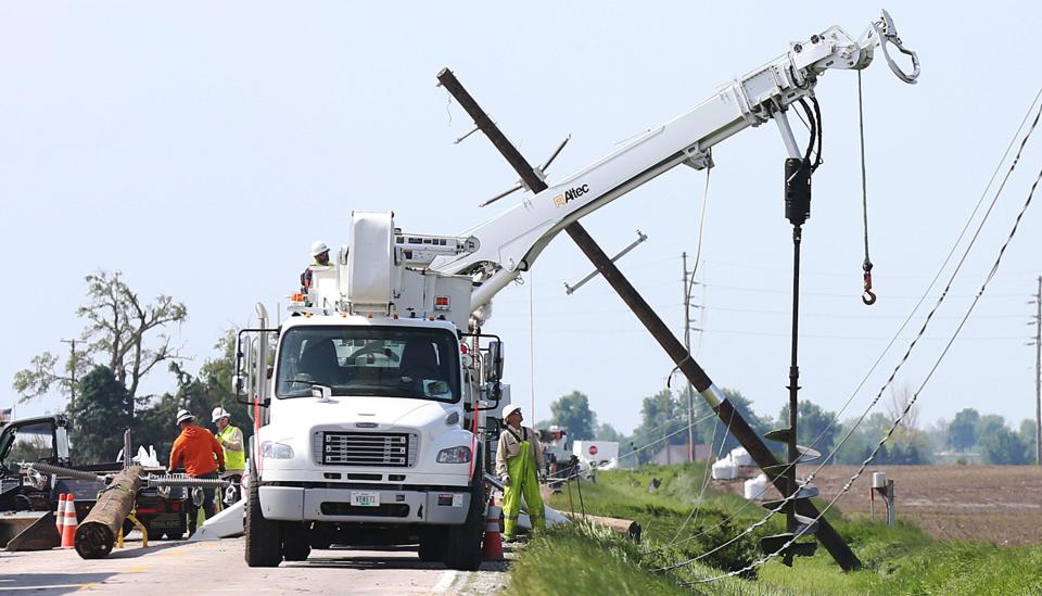 Workers restore power after a tornado took down powerlines near Colo on May 21.