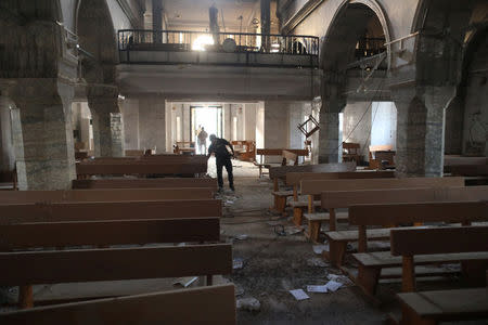 An Iraqi special forces soldier looks inside a church damaged by Islamic States fighters in Bartella, east of Mosul, Iraq, October 21, 2016. REUTERS/Goran Tomasevic