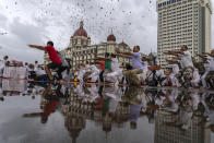 People perform Yoga to mark International Day of Yoga infront of Taj Mahal Palace hotel in Mumbai, India, Tuesday, June 21, 2022. Yoga enthusiasts across the world Tuesday took part in mass yoga events to mark Yoga Day. (AP Photo/Rafiq Maqbool)