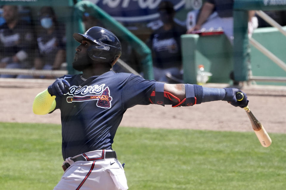 Marcell Ozuna de los Bravos de Atlanta da seguimiento tras baatear un jonrón de tres carreras en la tercera entrada en el juego de exhibición ante los Medias Rojas de Boston, el 16 de marzo de 2021. (AP Foto/John Bazemore)