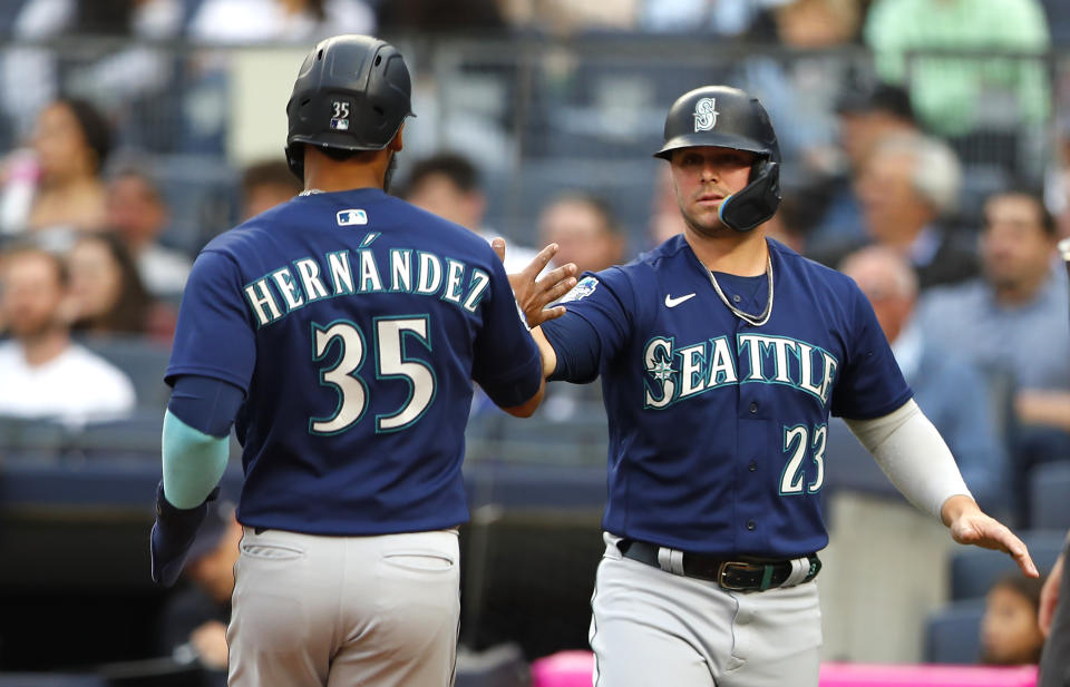 Seattle Mariners' Teoscar Hernandez (35) and Ty France (23) celebrate after scoring against the New York Yankees during the first inning of a baseball game Thursday, June 22, 2023, in New York. (AP Photo/Noah K. Murray)