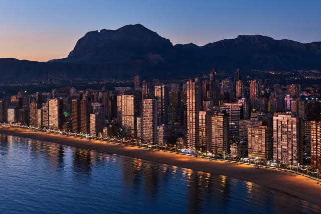 Panoramic View Of Illuminated Cityscape Against Sky At Sunset