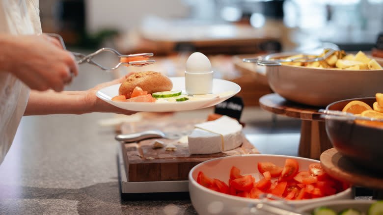 Woman selecting food from buffet