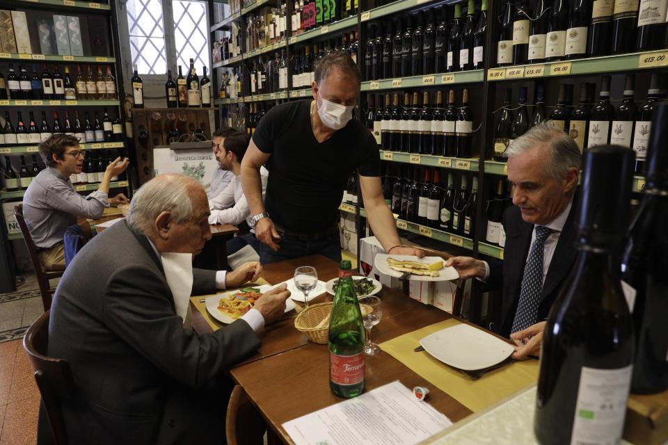 People gather inside a restaurant in downtown Rome, Tuesday, June 1, 2021. Starting Tuesday, customers were again allowed to access bars and restaurants, that were previously only permitted to serve outside or prepare for takeaway because of Covid restrictions. (AP Photo/Gregorio Borgia)