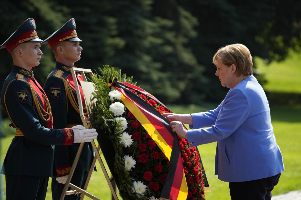 German Chancellor Angela Merkel, right, attends a wreath laying ceremony at the Tomb of Unknown Soldier in Moscow, Russia, Friday, Aug. 20, 2021, prior to talks with Russian President Vladimir Putin. The talks between Merkel and Putin are expected to focus on Afghanistan, the Ukrainian crisis and the situation in Belarus among other issues. (AP Photo/Alexander Zemlianichenko, Pool)