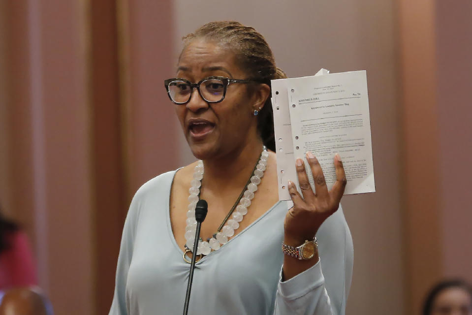 State Sen. Holly Mitchell, D-Los Angeles, chairwoman of the Senate Budget and Fiscal Review Committee holds up a copy of the budget as she urges lawmakers to approve the state spending plan, in Sacramento, Calif., Thursday, June 13, 2019. Both houses of the Legislature approved the $214.8 billion state budget that spends more on health care and education, bolsters the state's top firefighting agency and boost state reserves. (AP Photo/Rich Pedroncelli)