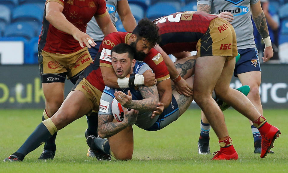 <p>Rugby-Spieler Oliver Roberts von den Huddersfield Giants touchierte bei diesem Fall zunächst nicht einmal den Boden. Er wurde von den Verteidigern der Catalans Dragons „aufgehalten“. (Bild: Action Images/Craig Brough) </p>