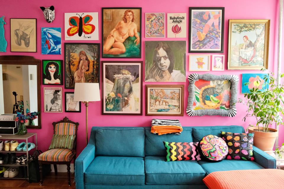 The vibrant living room in all its glory: Paintings by up-and-coming artists from both Zoe’s and Buzz’s personal collections (the two central portraits of women’s faces are by Brooklyn-based painter Anthony Cudahy) sit alongside their beloved childhood art. The sequin pillows by Zoe are sold separately or together.