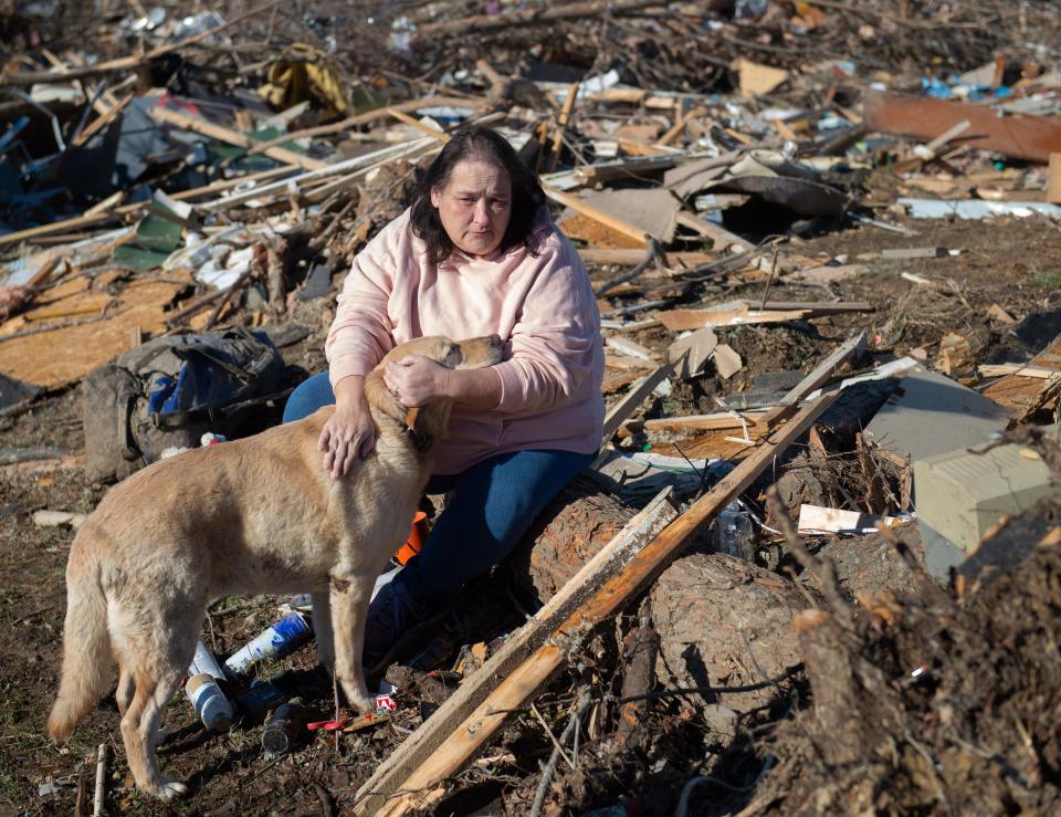 Charlene Stanley of Central City, Ky., and Gus offer comfort to eachother as they search the debris that once was her sister-in-law's home after the tornado in Bremen, Ky., Sunday, Dec. 12, 2021.  Gus lost his best canine friend from the tornado that Friday night.