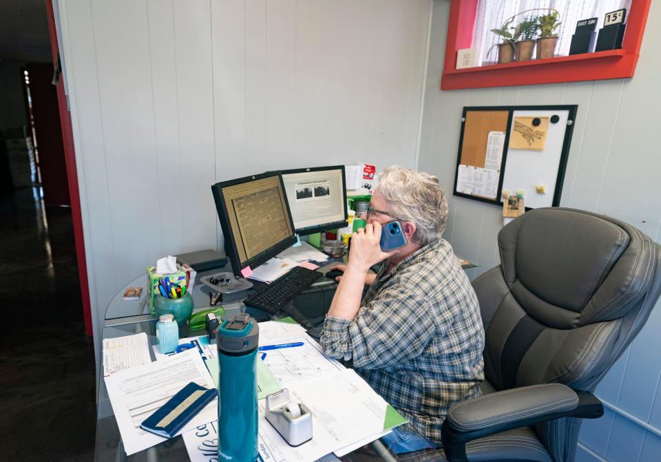 Barbara Ireland, 72, of Hudson, works the phone at the Hudson Post-Gazette on Monday, July 1, 2024. Ireland bought the paper in 2018 and employed her niece Rachel Stiverson, 53, of Hudson, to assist her in running the paper that includes story writing and photography.