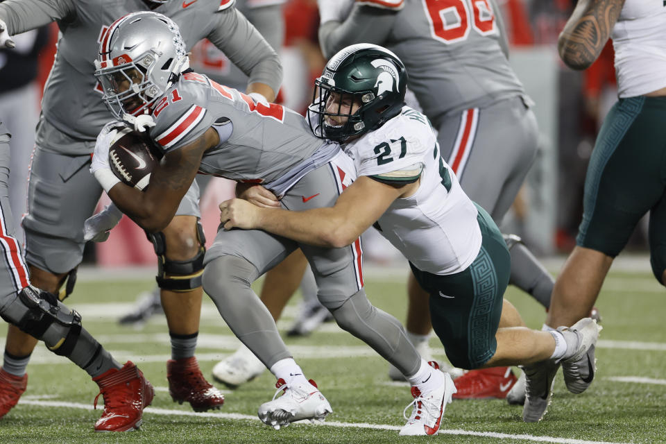 Ohio State running back Evan Pryor, left, is dragged down by Michigan State linebacker Cal Haladay during the second half of an NCAA college football game Saturday, Nov. 11, 2023, in Columbus, Ohio. (AP Photo/Jay LaPrete)