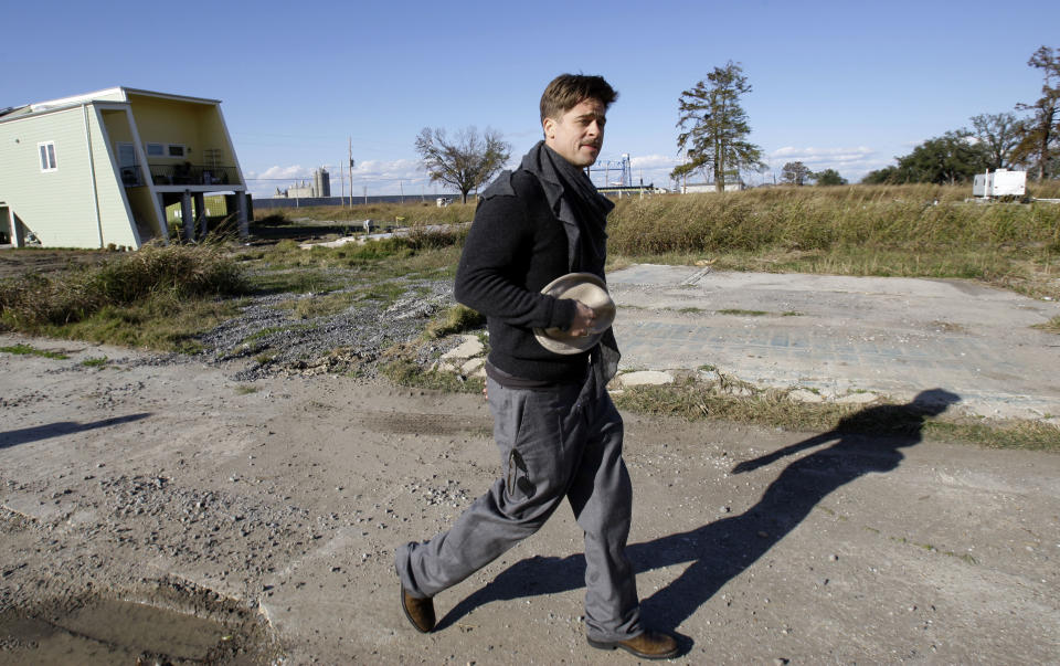 En esta foto de archivo del 1 de diciembre del 2008, Brad Pitt camina en el Lower 9th Ward entre una casa construida por la fundación Make It Right Foundation y un tráiler de FEMA en Nueva Orleans. Un abogado planea demandar a la fundación de Pitt por el deterioro de casas construidas en el área, una de las más afectadas por el huracán Katrina. (AP Foto/Alex Brandon, Archivo)