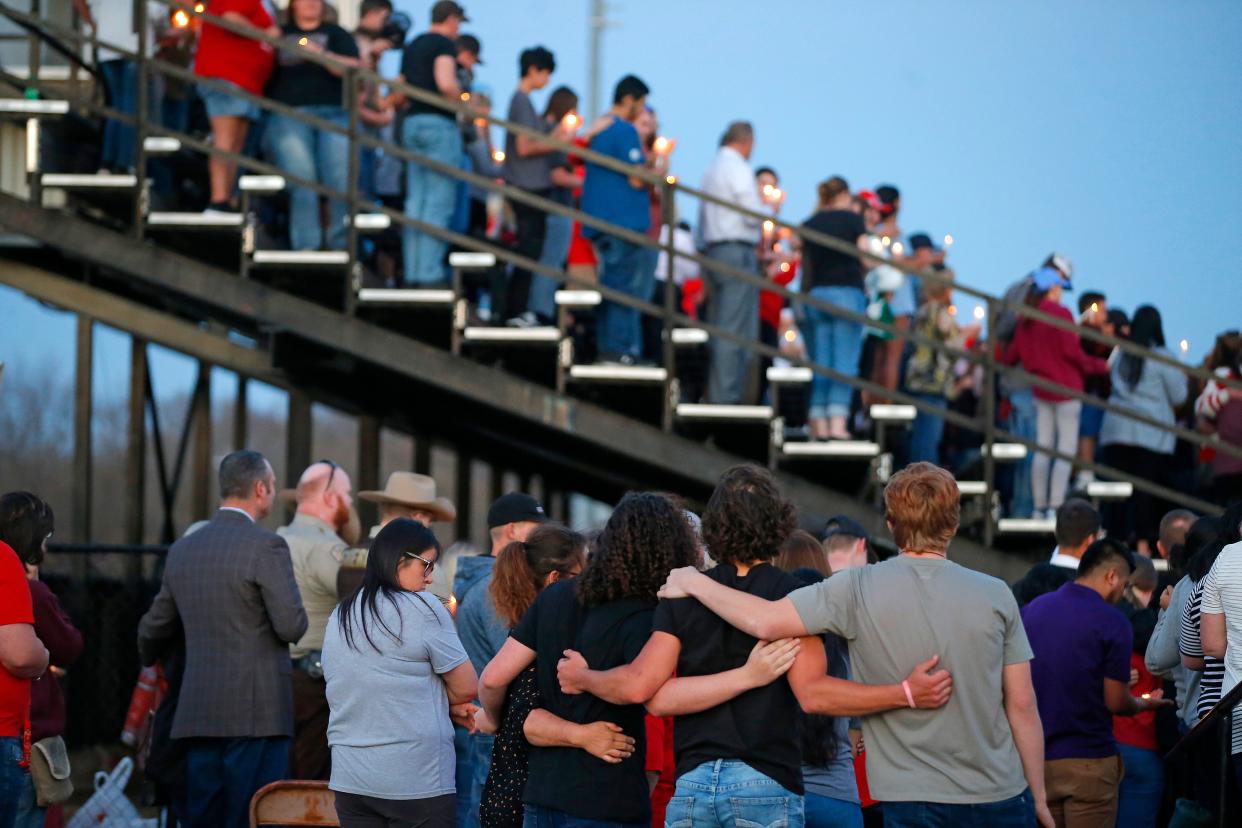 People embrace during a vigil for six Tishomingo high school students who died in a vehicle collision in 2022.