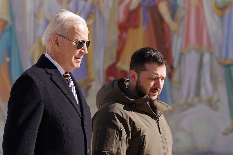 El presidente de EE. UU., Joe Biden camina junto al presidente de Ucrania, Volodymyr Zelensky (der.), cuando llega de visita a Kiev el 20 de febrero de 2023