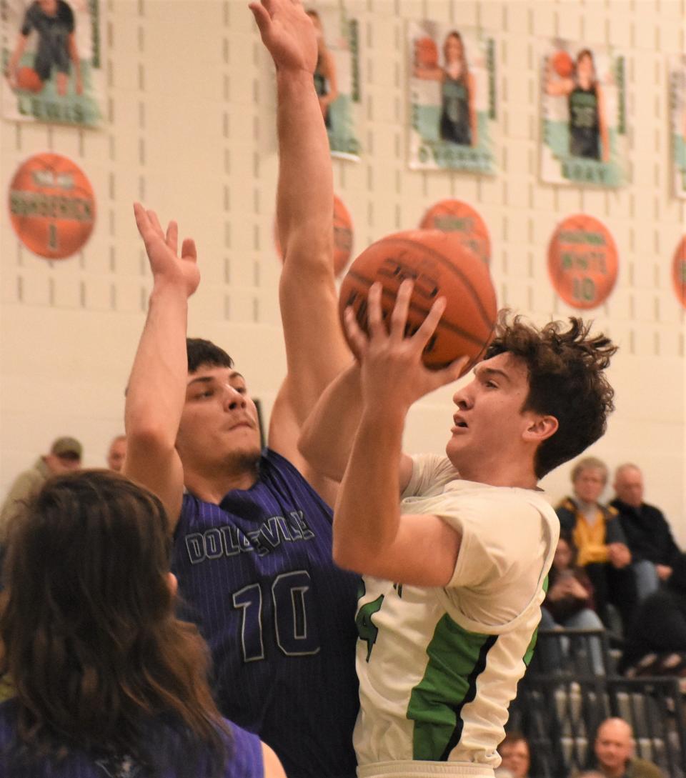 Herkimer Magician Kyle Carney (right) goes up for a shot Friday with Kamryn Comstock defending for the Dolgeville Blue Devils.