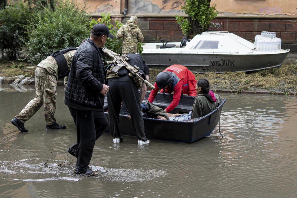 Emergency teams help rush to safety injured civilian evacuees who had came under fire from Russian forces while trying to flee by boat from the Russian-occupied east bank of a flooded Dnieper River to Ukrainian-held Kherson, on the western bank. in Kherson, Ukraine, on Sunday, June 11, 2023. (AP Photo)