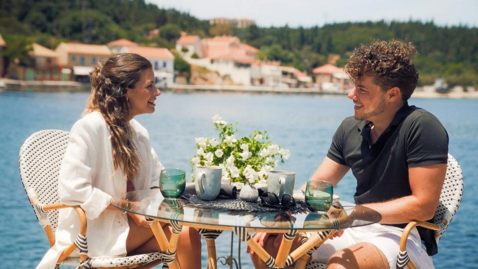 Bachelorette Maxime sitzt mit Österreicher Raphael an einem kleinen Glastisch am Meer