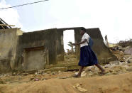 A school girl walks past houses that were demolished on public health grounds in the Gesco neighborhood of Abidjan, Ivory Coast, Wednesday, Feb. 28, 2024. Rapid urbanisation has led to a population boom and housing shortages in Abidjan, where nearly one in five Ivorians reside, many of them in low-income, crowded communes like the ones in the Gesco and Sebroko districts being demolished on public health grounds. (AP Photo/Diomande Ble Blonde)