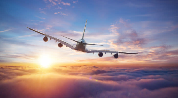 image of a plane flying in the sky representing airline stocks