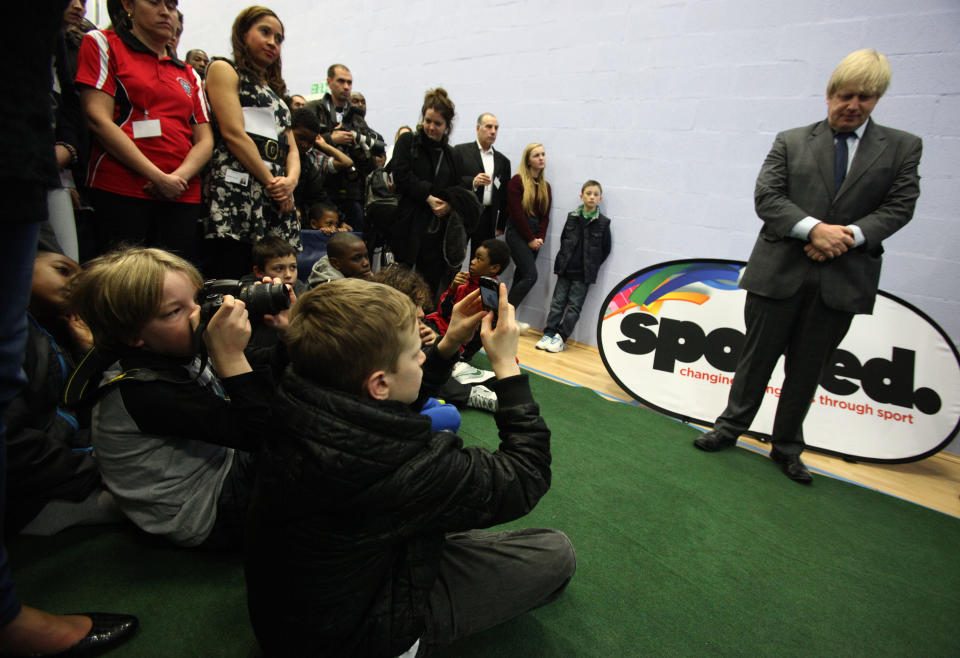 Children take pictures of Mayor of London Boris Johnson during his visit to a 100-year-old youth club that has helped 10,000 boys, at Crown and Manor Youth Club in north London. PRESS ASSOCIATION Photo. Picture date: Thursday February 28, 2013. Photo credit should read: Yui Mok/PA Wire