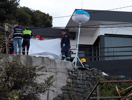 Rescue workers use blanket to cover bodies at the scene of a bus accident in Canico, in the Portuguese Island of Madeira, April 17, 2019. REUTERS/Duarte Sa