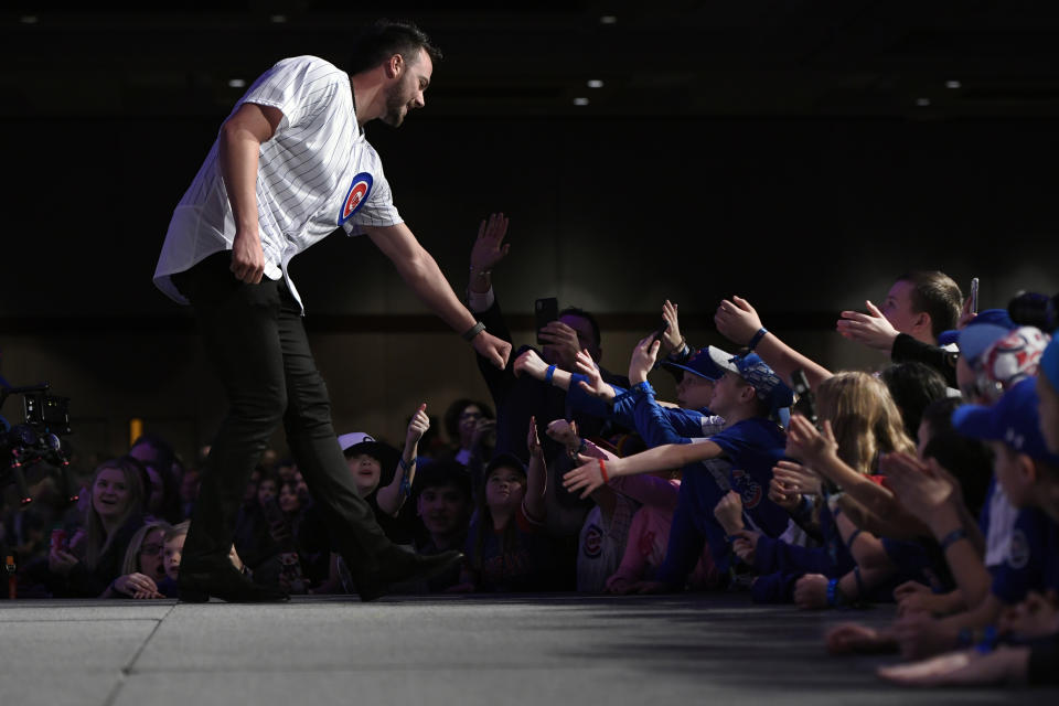 Chicago Cubs' Kris Bryant, left, fist-bumps fans after being announced during the baseball team's convention, Friday, Jan. 17, 2020, in Chicago. (AP Photo/Paul Beaty)