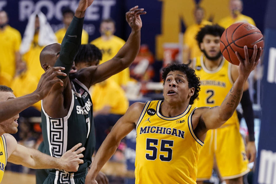 Michigan guard Eli Brooks (55) makes a layup as Michigan State guard Joshua Langford (1) defends during the first half of an NCAA college basketball game, Thursday, March 4, 2021, in Ann Arbor, Mich. (AP Photo/Carlos Osorio)