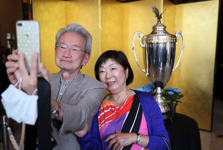 People take pictures with The President’s Cup, which U.S. President Donald Trump will present to the winner of a sumo wrestling tournament, is on display at the Palace Hotel in Tokyo, Japan May 26, 2019. REUTERS/Jonathan Ernst