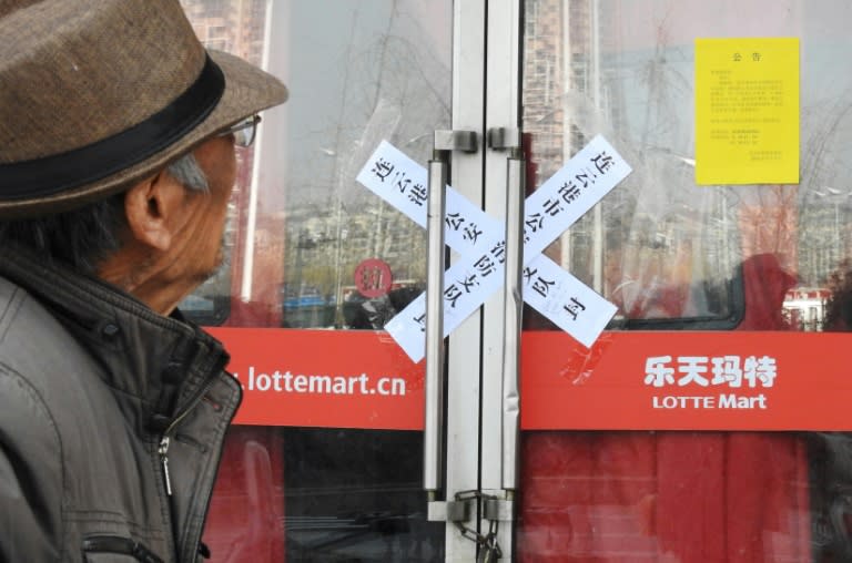 A man looks at the door of a closed Lotte store in Lianyungang in China's eastern Jiangsu province on March 7, 2017