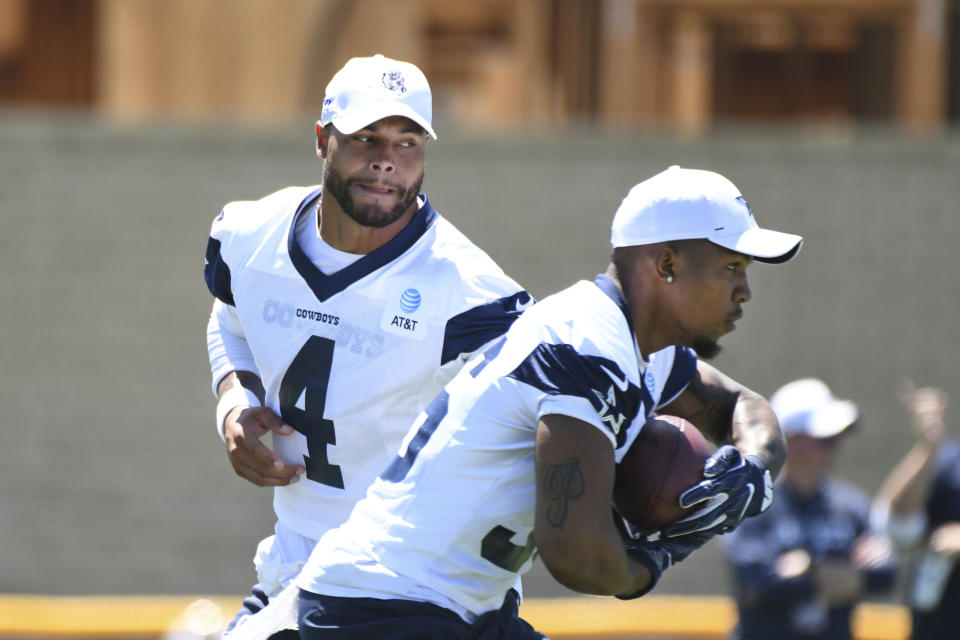 Dallas Cowboys quarterback Dak Prescott (4) hands the football to running back Tony Pollard during practice at the NFL football team's training camp in Oxnard, Calif., Saturday, July 27, 2019. (AP Photo/Michael Owen Baker)