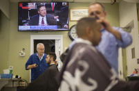 <p>Barbers cut hair for customers as televised coverage of former FBI director James Comey testifying is seen on television screen at Puglisi Hair Cuts in the Foggy Bottom neighborhood of Washington, June 8, 2017. (Pablo Martinez Monsivais/AP) </p>