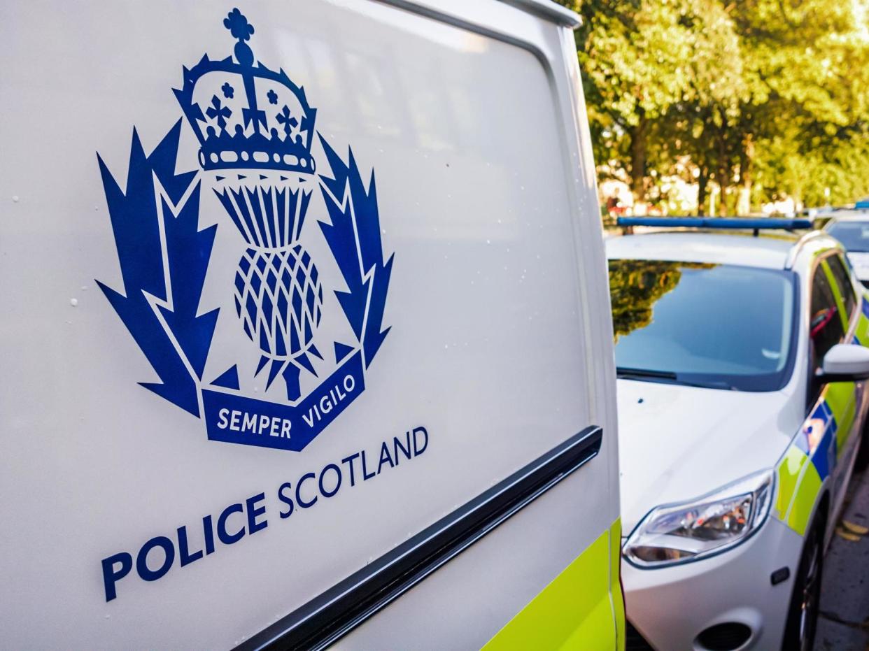 The Police Scotland logo on the side of a police van, with other police vehicles in the background: Getty Images