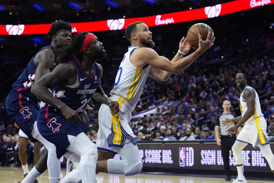 Golden State Warriors' Stephen Curry, right, goes up for a shot against Philadelphia 76ers' Patrick Beverley during the second half of an NBA basketball game, Wednesday, Feb. 7, 2024, in Philadelphia. (AP Photo/Matt Slocum)