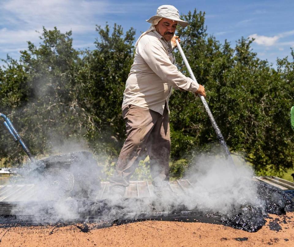 Gilberto Lujano, 49, spreads tar while working on a roof on Tuesday, May 2, 2023, in Homestead, Fla. MATIAS J. OCNER/mocner@miamiherald.com