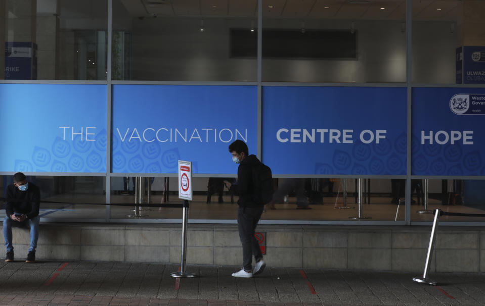 People outside the Vaccination Centre of Hope at the Cape Town International Convention Centre in Cape Town, South Africa, Tuesday July 27, 2021. Hitting its stride after a faltering start, South Africa’s mass vaccination campaign gave jabs to 220,000 people a day last week and is accelerating toward the goal of 300,000 per day. With large deliveries of doses arriving and some vaccines being assembled here, South Africa appears on track to inoculate about 35 million of its 60 million people by the end of the year. (AP Photo/Nardus Engelbrecht)