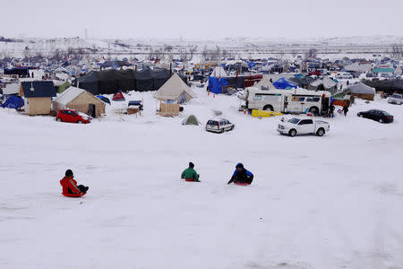 Children sled down a hill inside of the Oceti Sakowin camp as "water protectors" continue to demonstrate against plans to pass the Dakota Access pipeline near the Standing Rock Indian Reservation, near Cannon Ball, North Dakota, U.S., December 2, 2016. REUTERS/Lucas Jackson