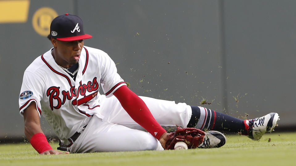Atlanta Braves left fielder Ronald Acuna Jr. (13) recovers a ball hit by Los Angeles Dodgers' Yasiel Puig (66) for a base hit during the second inning in Game 4 of baseball's National League Division Series, Monday, Oct. 8, 2018, in Atlanta. (AP Photo/John Bazemore)