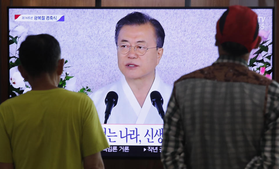 People watch a TV screen showing a live broadcast of South Korean President Moon Jae-in's speech during a ceremony to celebrate the Korean Liberation Day, marking the 74th anniversary of Korea's liberation from the Japanese colonial rule, at the Seoul Railway Station in Seoul, South Korea, Thursday, Aug. 15, 2019. The signs read: "Korean Liberation Day."(AP Photo/Ahn Young-joon)