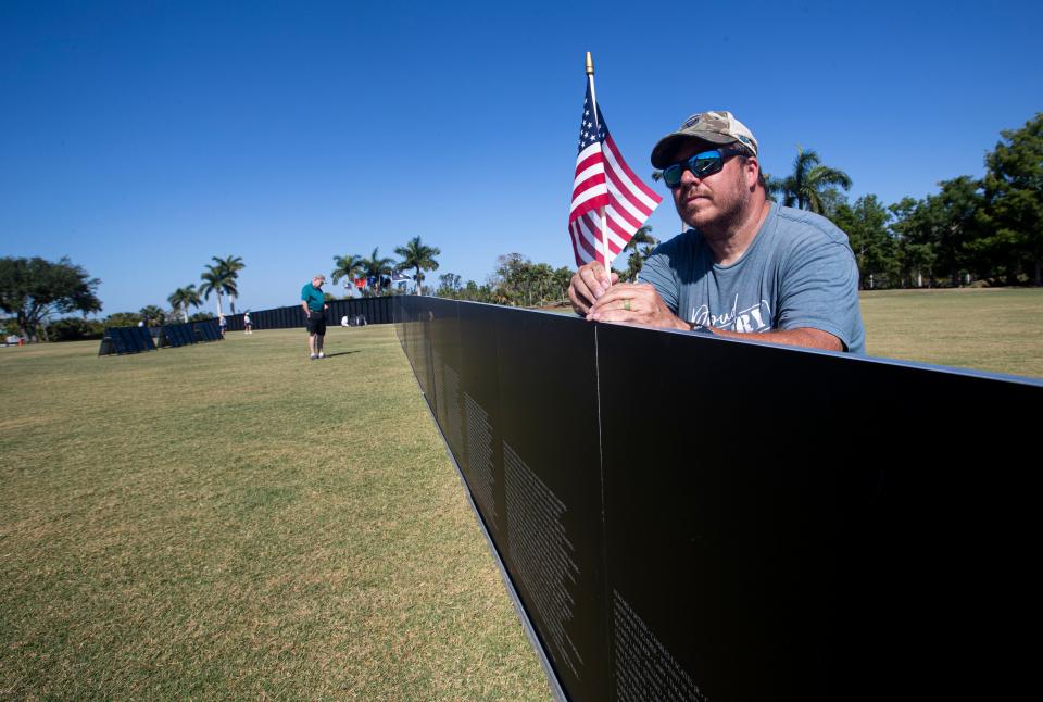 Wes Shivers from the Vietnam Traveling Wall and Cost of Freedom display places American flags on the Vietnam wall replica at Lakes Regional Park in Fort Myers on Thursday, April 25, 2024. The display is open to the public through Sunday evening at dusk.