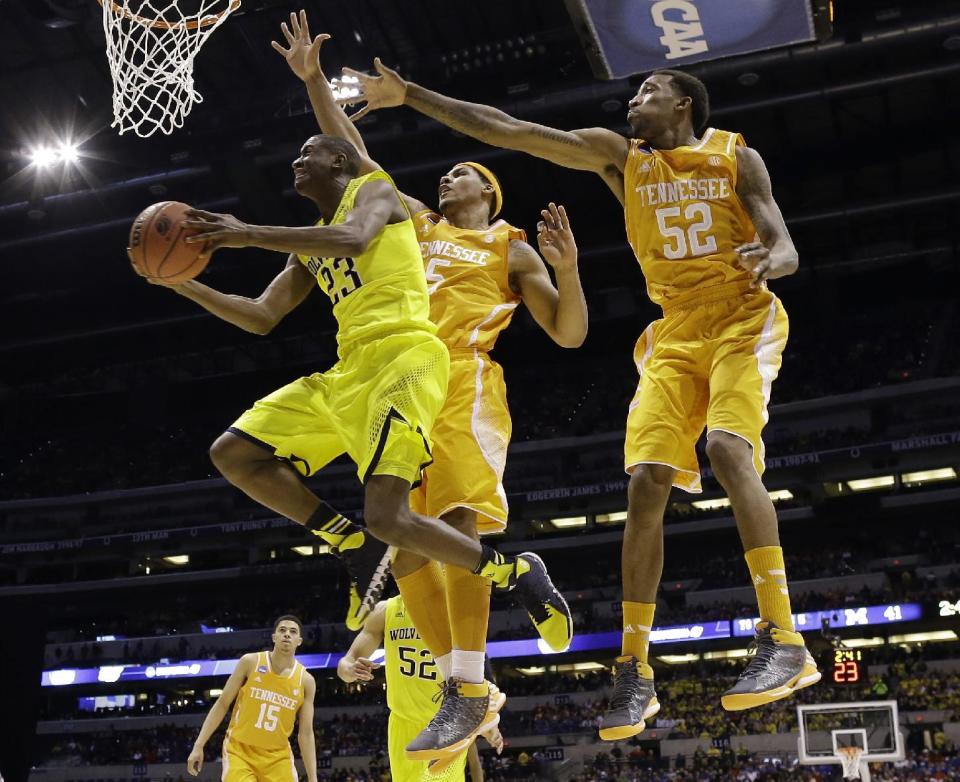 Michigan's Caris LeVert (23) shoots past Tennessee's Jarnell Stokes (5) and Jordan McRae (52) during the first half of an NCAA Midwest Regional semifinal college basketball tournament game Friday, March 28, 2014, in Indianapolis. (AP Photo/David J. Phillip)