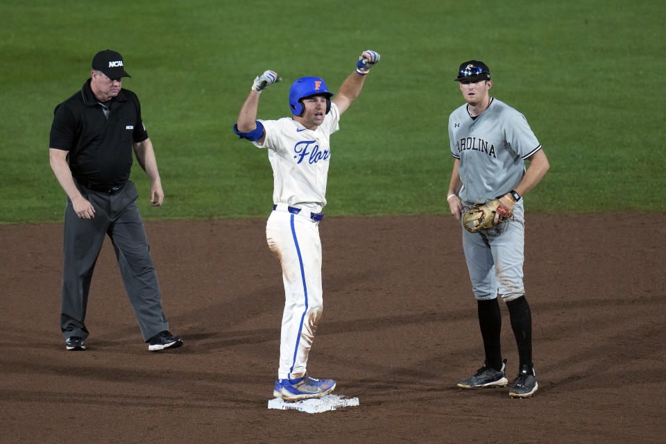 Florida's Colby Halter, center, celebrates after hitting a double in the fifth inning, next to South Carolina shortstop Braylen Wimmer duirng an NCAA college baseball tournament super regional game Friday, June 9, 2023, in Gainesville, Fla. (AP Photo/John Raoux)