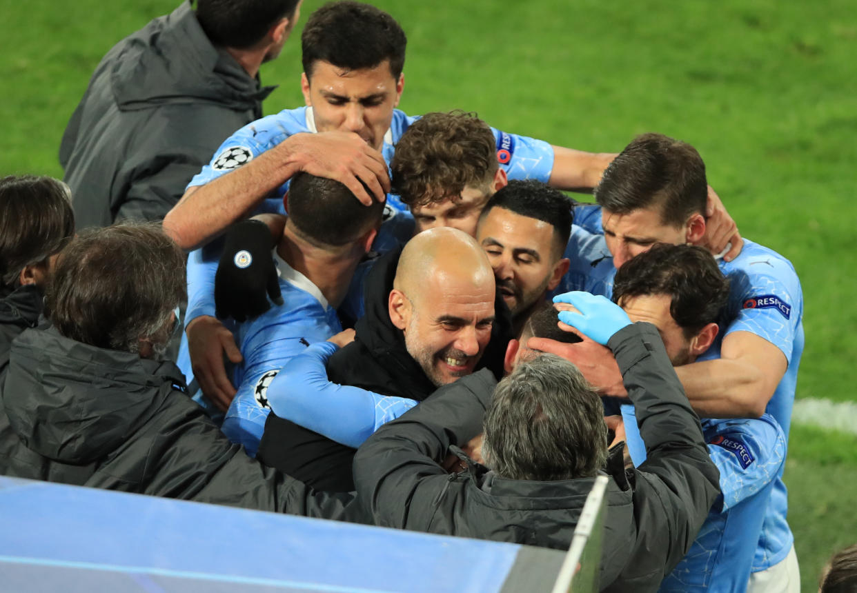 Manchester City players celebrating their second goal with manager Pep Guardiola.