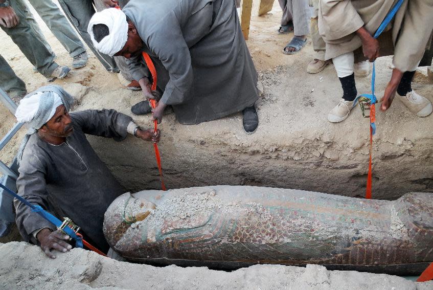 This photo released on Thursday, Feb. 13, 2014 by Egypt's Supreme Council of Antiquities, shows Egyptian men digging up a preserved wooden sarcophagus that dates back to 1600 BC, when the Pharaonic 17th Dynasty reigned, in the ancient city of Luxor, Egypt. Egypt’s Antiquities Minister says Spanish archeologists have unearthed a 3,600-year-old mummy in the ancient city of Luxor. (AP Photo/Egypt's Supreme Council Of Antiquities)