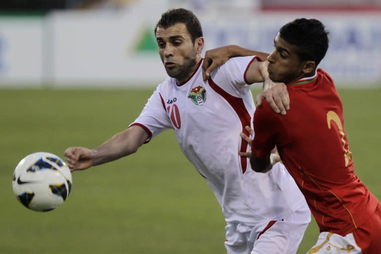 Oman's Mohammed Saleh al-Musalami (R) fights for the ball with Jordan's Ahmad Hayel during their 2014 FIFA World Cup qualifier match, in Amman, on June 18, 2013. Uzbekistan will seek atonement for a notorious incident which remains one of the dark episodes of Asian football when they head into a crunch W.Cup play-off against Jordan on Friday