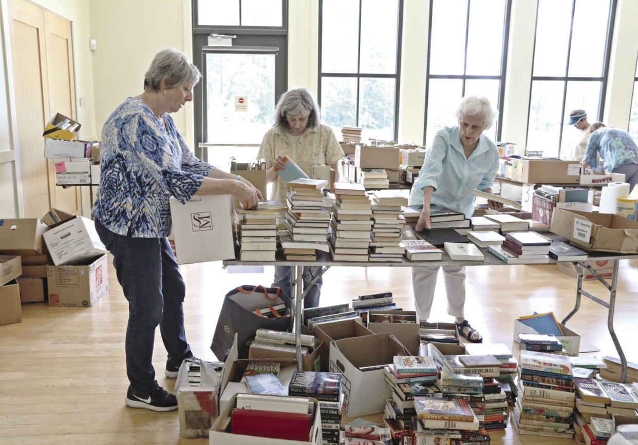 From left, Kathy Gallagher, Joanne Morrow and Cary Bailey organize books at Tiverton Public Library in preparation for a book sale in 2017.