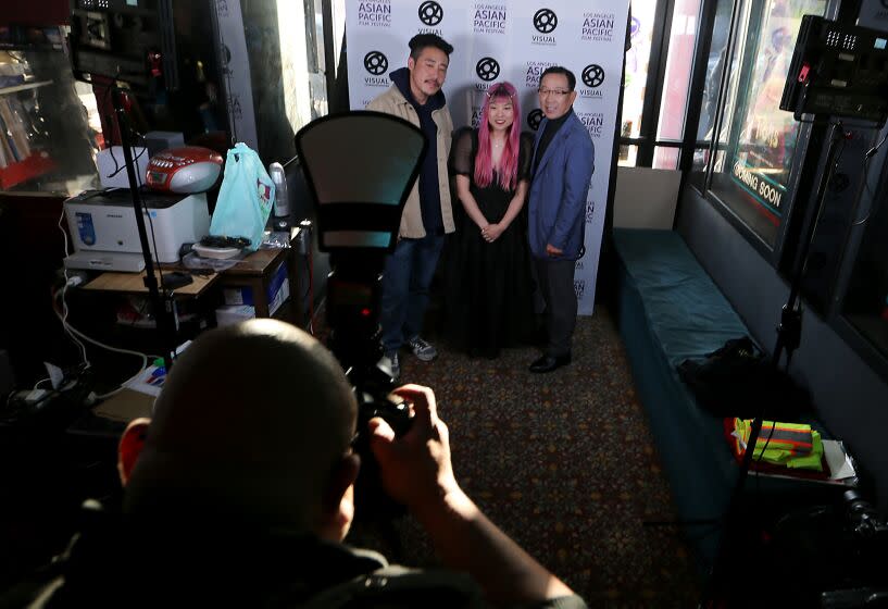 Gardena, CA - May 10: Filmmaker So Yun Eum, center, poses for pictures before the L.A. premier of her documentary. The film is called called Liquor Store Dreams, and features her father, Hae Sup Eum, right, and Danny Park, left,. So Yun Eum is a second generation Korean American and the film is about the Korean American merchant class. (Luis Sinco / Los Angeles Times)